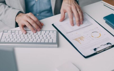 A man working with a financial report and keyboard in an office setting.