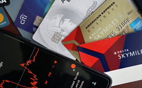Image showing credit cards and a financial market graph on a smartphone.